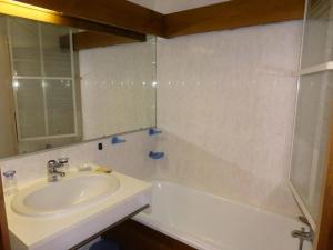 a bathroom with a sink and a tub and a mirror at Résidence Les Cimes D'or A - 2 Pièces pour 4 Personnes 704 in Les Contamines-Montjoie