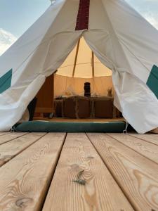 a tent with a bed and a wooden floor at Tipi Sioux in Belau