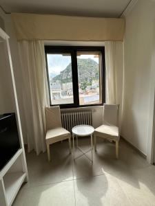 a room with a table and two chairs and a window at MIRA taormina rooms in Taormina