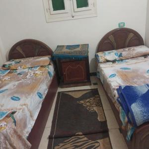 dos camas sentadas una al lado de la otra en una habitación en Adel Hotel, en Abu Simbel