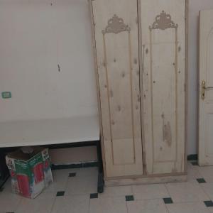 two wooden lockers in a room with a box at Adel Hotel in Abu Simbel