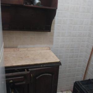 cocina con encimera y pared de azulejos blancos en Adel Hotel, en Abu Simbel
