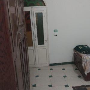 Habitación con puerta y suelo de baldosa. en Adel Hotel, en Abu Simbel