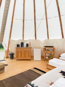 a room in a canvas tent with wooden floors at Tipi Wappo in Belau
