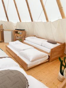 a room with three beds in a tent at Tipi Wappo in Belau