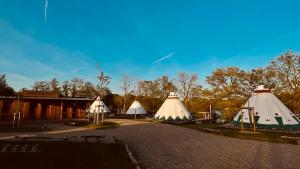 un grupo de tres tiendas de campaña sentadas al lado de un edificio en Tipi Wappo, en Belau