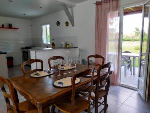 cocina y comedor con mesa de madera y sillas en Amarante des Landes, 