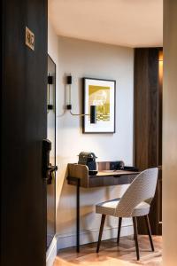 a hotel room with a desk and a chair at Hotel Flanelles Paris in Paris