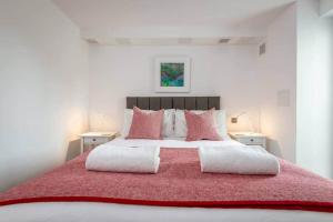 Un dormitorio con una gran cama roja con almohadas rosas en Luxury Garden Apartment in St Andrews, en St Andrews