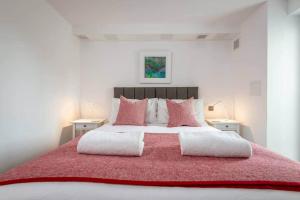 um quarto com uma grande cama vermelha com almofadas cor-de-rosa em Luxury Garden Apartment in St Andrews em St. Andrews