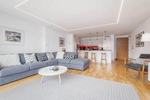 uma sala de estar com um sofá azul e uma mesa em Luxury Garden Apartment in St Andrews em St. Andrews