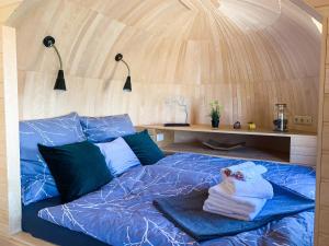 uma cama num quarto redondo com tecto em madeira em Igluhut Molendini em Püchau