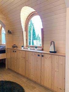 a room with wooden cabinets and an arched window at Igluhut Molendini in Püchau