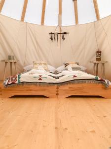 a bed in a tent in a room at Tipi Kiowa in Belau