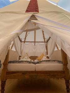 een bed in een tent met een baldakijn bij Tipi Blackfoot in Belau