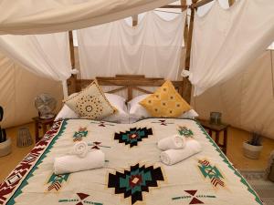 een bed met handdoeken en kussens erop bij Tipi Blackfoot in Belau