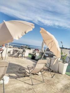 a group of chairs and tables with umbrellas at Apartments Mitende in Budva