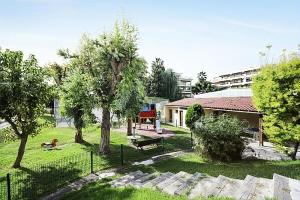 a park with a bench and trees and a building at Résidence Héliotel Marine - maeva Home - Studio 4 personnes - Confort 084 in Cros-de-Cagnes