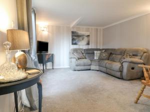 a living room with a couch and a table at The Lodge at Wildersley Farm in Belper