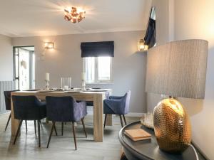 a dining room with a table and chairs and a lamp at The Lodge at Wildersley Farm in Belper