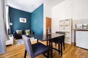 a dining room with a black table and chairs at The Whitecross Street Collection in London