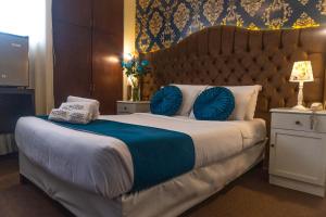 Habitación de hotel con cama grande con almohadas azules en AM Hotels Collect en Arequipa