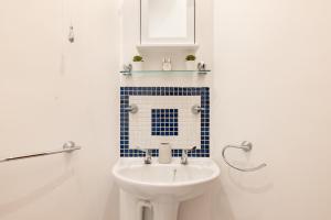 a bathroom with a white toilet and a sink at The Whitecross Street Collection in London