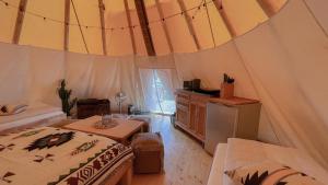 - une chambre avec un lit et une table dans une tente dans l'établissement Tipi Alabama, à Falkenberg