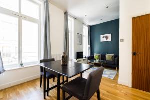 a living room with a table and chairs and a couch at The Whitecross Street Collection in London