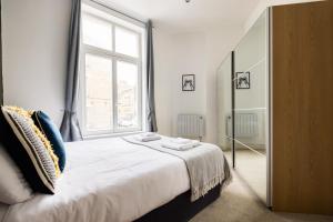 a bedroom with a large bed with a large window at The Whitecross Street Collection in London