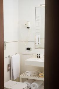 uma casa de banho com um lavatório, um WC e um espelho. em Grand Hotel Telese em Telese Terme