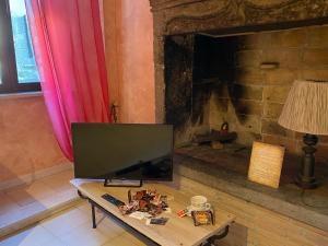 un soggiorno con TV e camino di La dimora nel castello a Bomarzo