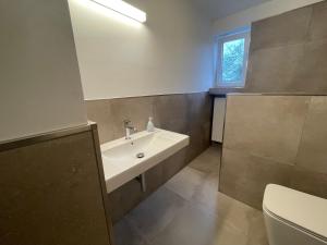 La salle de bains est pourvue d'un lavabo et de toilettes. dans l'établissement Ferienwohnung Wohnung Krefeld Forstwald Höltehoffe, à Krefeld