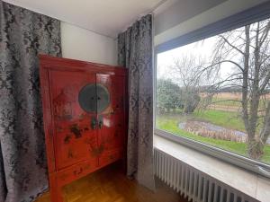 a red cabinet in a room with a window at Ferienwohnung Wohnung Krefeld Forstwald Höltehoffe in Krefeld