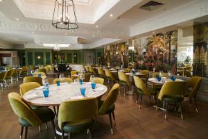 um restaurante com mesas e cadeiras num quarto em Down Hall Hotel em Bishops Stortford