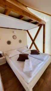 un grande letto bianco in una camera con pavimenti in legno di Safarizelt Simba a Falkenberg