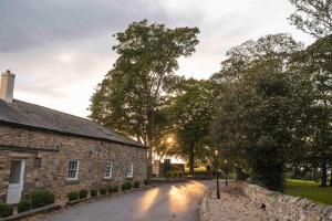 an old stone building and a street with trees at 61 Durham in Durham +50 photos