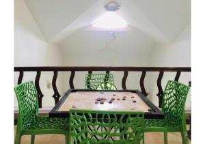 eine Tischtennisplatte mit grünen Stühlen auf dem Balkon in der Unterkunft Spice Fields Cottage 3 Bedroom - Wayanad in Wayanad
