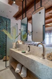 a bathroom with two sinks and two mirrors at Mansio Boutique Hotel in Rethymno
