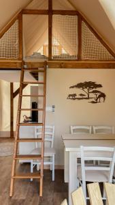 a room with a bunk bed and a table and chairs at Safarizelt Kiara in Falkenberg