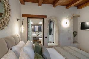 a bedroom with a bed and a bathroom at Mansio Boutique Hotel in Rethymno Town
