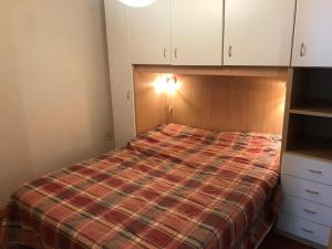 Dormitorio pequeño con cama y armarios blancos en Résidence Alpet Ii - 2 Pièces pour 6 Personnes 374, en Montgenèvre