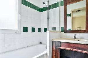 łazienka z wanną, umywalką i lustrem w obiekcie Les Maisons du Domaine du Golf de Pinsolle - maeva Home - Maison 3 pièces 6 personnes - Sélection MAE-9964 w mieście Soustons