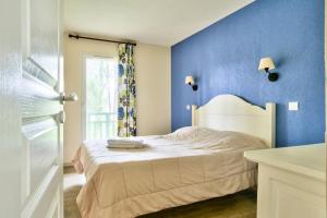 niebieska sypialnia z łóżkiem i oknem w obiekcie Les Maisons du Domaine du Golf de Pinsolle - maeva Home - Maison 3 pièces 6 personnes - Sélection MAE-9964 w mieście Soustons