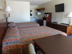 Habitación de hotel con cama y TV de pantalla plana. en National 9 Inn, en Garden City