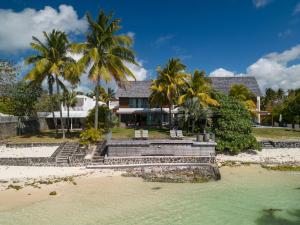 a house on the beach with palm trees at Villa Rubis by muse villas in Belle Mare