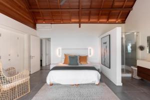 a bedroom with a king sized bed and a chair at Villa Rubis by muse villas in Belle Mare