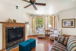a living room with a fireplace and a ceiling fan at Portland Park Townhome Unit 1 in Ouray