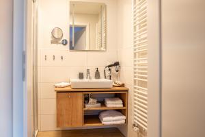 a bathroom with a sink and a mirror at Hotel Seeblick in Thülsfeld +31 photos
