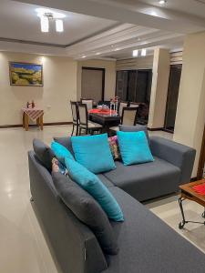 sala de estar con sofá gris y almohadas azules en Torres de Atitlan 14 nivel, en Panajachel